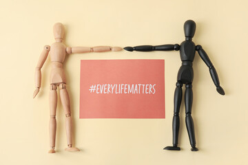 Wooden mannequins and paper sheet with hashtag #EVERYLIFEMATTERS on light background