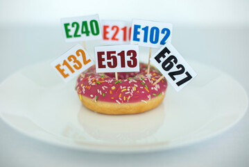 Plate with Donut with Cards with Names of Harmful Additive Chemicals Stuck in it