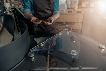 Baristas hands demonstrate freshly roasted coffee beans ready for selling