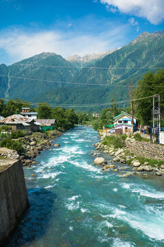 Beautiful view of Pahalgam during Summer season surrounded by greenry Himalayas mountains and green fir and pine tree line forest landscape.