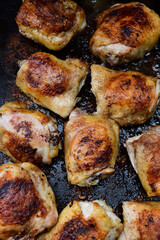 Chicken thighs grilling on a cast iron skillet.