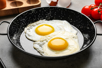 Frying pan with tasty eggs on table, closeup