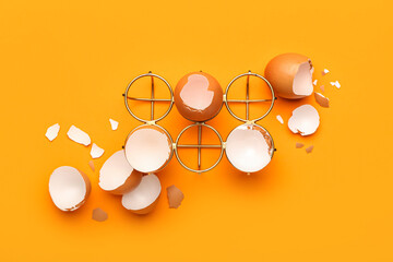 Composition with holder and egg shells on color background