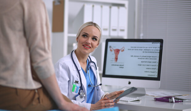 Doctor and patient discussing something while sitting at the table . Medicine and health care concept. Doctor and patient