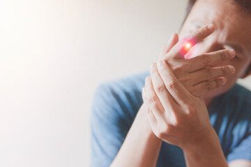 Close up man suffering from finger pain sitting on work room, health problem and people concept