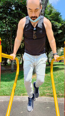 Fototapeta premium hombre haciendo ejercicio en una máquina del parque en un día soleado 5