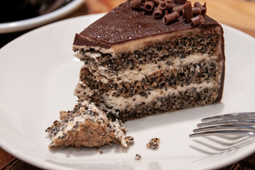 Still life with food: poppy seed cake in a white plate in a cafe