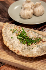 Still life with food: kutaba on a wooden board and khinkali
