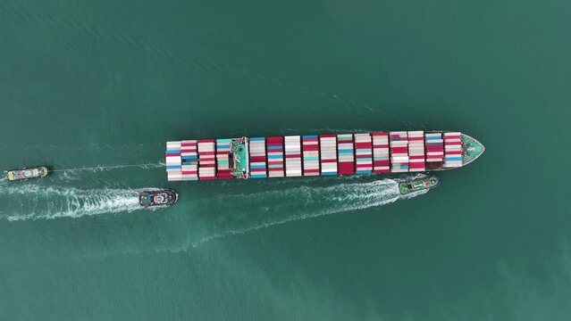 Top of cargo container ship carrying container running with tug boat for export import from cargo yard port to custom ocean concept freight shipping by ship. Tug boat drage cargo vessel to sea port