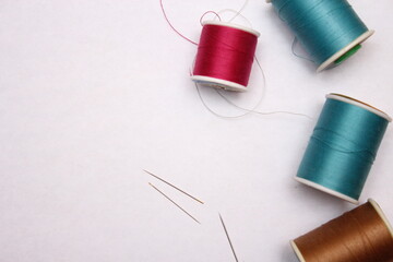Multi-colored threads and old scissors spread out on a white floor, retro scissors, flat lay, copy...