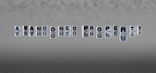 abandoned property word or concept represented by black and white letter cubes on a grey horizon background stretching to infinity