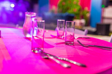 Restaurant table glasses, plates and cutlery close up