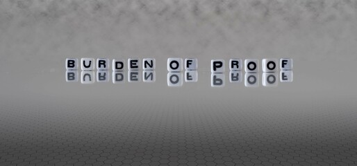 burden of proof word or concept represented by black and white letter cubes on a grey horizon...