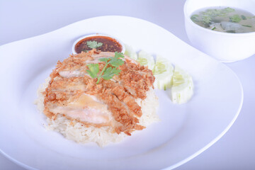 Thai crispy chicken served on steamed rice with sweet chilli sauce and cucumber slices. Traditional south east asian cuisine.and isolate background 