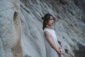 海岸の岩場で佇む女性