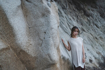 海岸の岩場で佇む女性