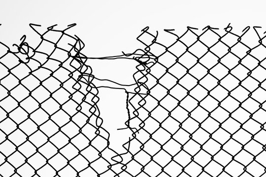 Opening in metallic fence against a blue sky with white clouds. Challenge. uncertainty. breakthrough concept. metaphor. Chain-link, wire netting, wire-mesh, cyclone hurricane fence