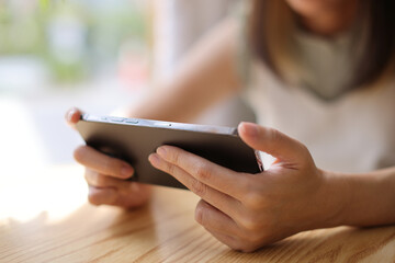 Woman hand using a smartphone for Stock exchange trading online in the coffee shop, business concept