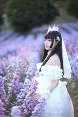 Beautiful young woman with white lolita dress with european garden Japanese fashion