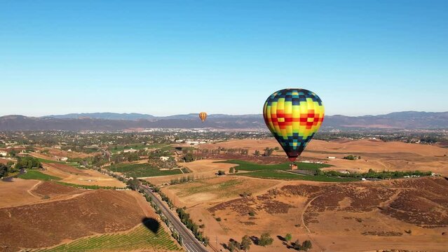 Colorful Hot air balloons in the sky over Temecula Landscape, California. Aerial dolly motion