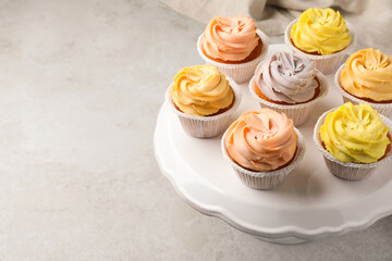 Stand with tasty cupcakes on light table. Space for text