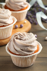 Tasty cupcakes with cream on wooden table, closeup