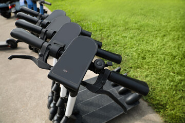 Row of electric scooters outdoors, closeup. Rental service