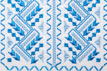 Beautiful light blue Ukrainian national embroidery on white fabric, top view
