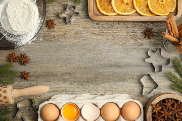 Flat lay composition with cookie cutters and ingredients on wooden table, space for text. Christmas biscuits