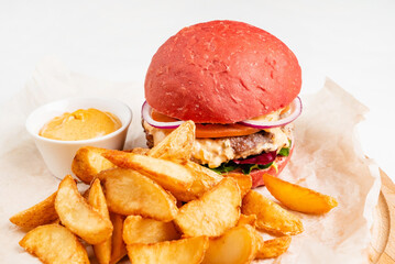 red burger with roasted potatoes and sauce