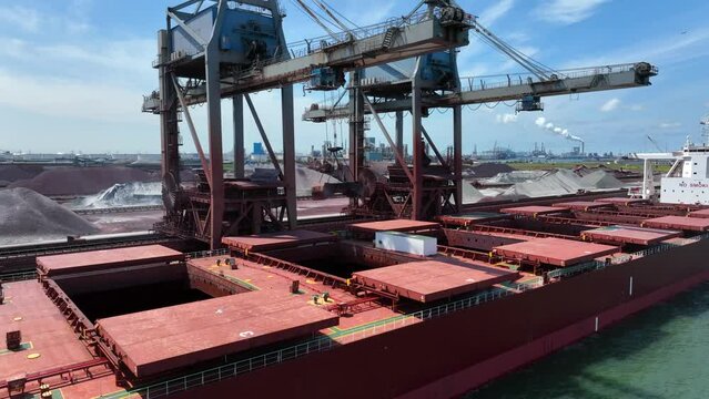 Cranes Unloading Commodities From a Bulk Carrier Ship at Port