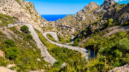 View to the mediterranean sea down the narrow Serra de Tramuntana pass road MA-2141 winding in...