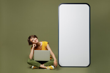 Full size young woman she 20s wear yellow t-shirt sit near big huge blank screen mobile cell phone...