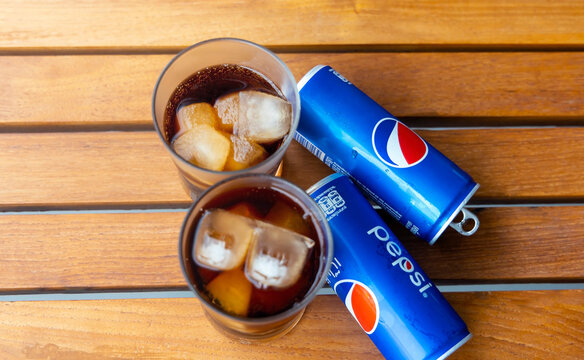 BANGKOK-THAILAND-MAY-29-2022 : Woman hand with  Pepsi Cola softdrink can and a glass of Pepsi, a carbonated soft drink produced and manufactured by Pepsi in thailand