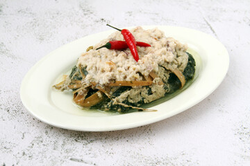 Freshly cooked Filipino dish called Spicy Pinangat Bicol or dried fish, pork, shrimp paste and gabi leaves