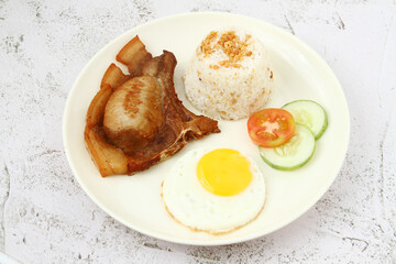 Freshly cooked Filipino food called Pork Chop Silog or pork chop, egg and fried rice