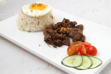 reshly cooked Filipino food called Tapsilog or thin beef slices, egg and fried rice
