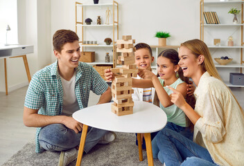 Happy family playing board games together. Parents and kids having fun at home. Cheerful, joyful...
