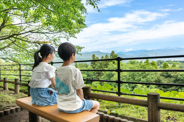 山の頂上からの景色を見ている日本人の小学生