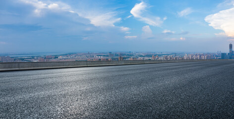 Empty asphalt road and city skyline with building scenery at dusk