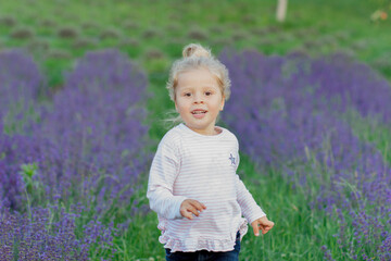 Little beautiful girl on the field of lavender flowers