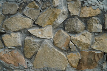 a fragment of a city wall made of natural stone of various textures