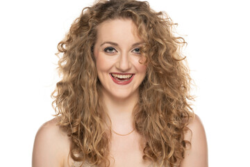 Attractive blonde woman with curly beautiful hair smiling on white background