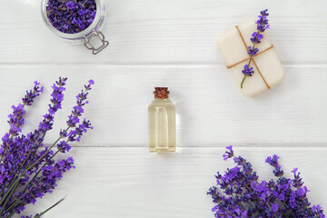 Lavender soap bars and spa products with lavender flowers on a white wooden table