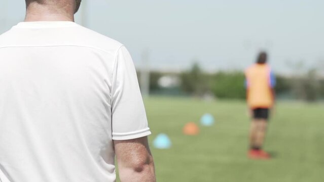 Soccer coach looking out at players training