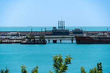 Oil product tanker Akhty is moored at oil terminal of Novorossiysk Commercial Sea Port. Close-up of bow of tanker. Turquoise sea water. Sea is calm.. Novorossiysk, Russia 02 July 2022