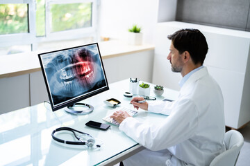 Dentist Looking At Teeth X-ray On Computer