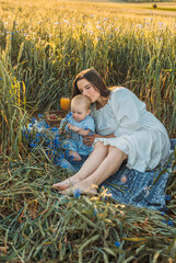 mother and daughter having a picnic outdoors in the field. Playing and having fun with little baby . Happy family concept