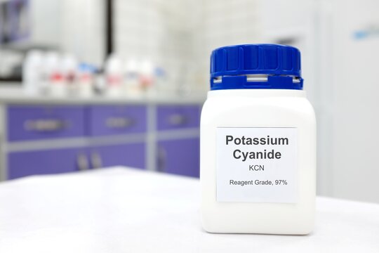 Selective focus of a bottle of Potassium Cyanide pure chemical compound. White laboratory background.