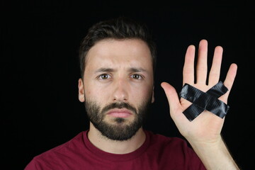 Young man showing black dutch tape cross on his hand 